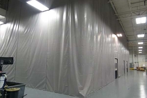 The pvc fabric partition is suspended from the existing roof structure to create a semi-permanent static wall